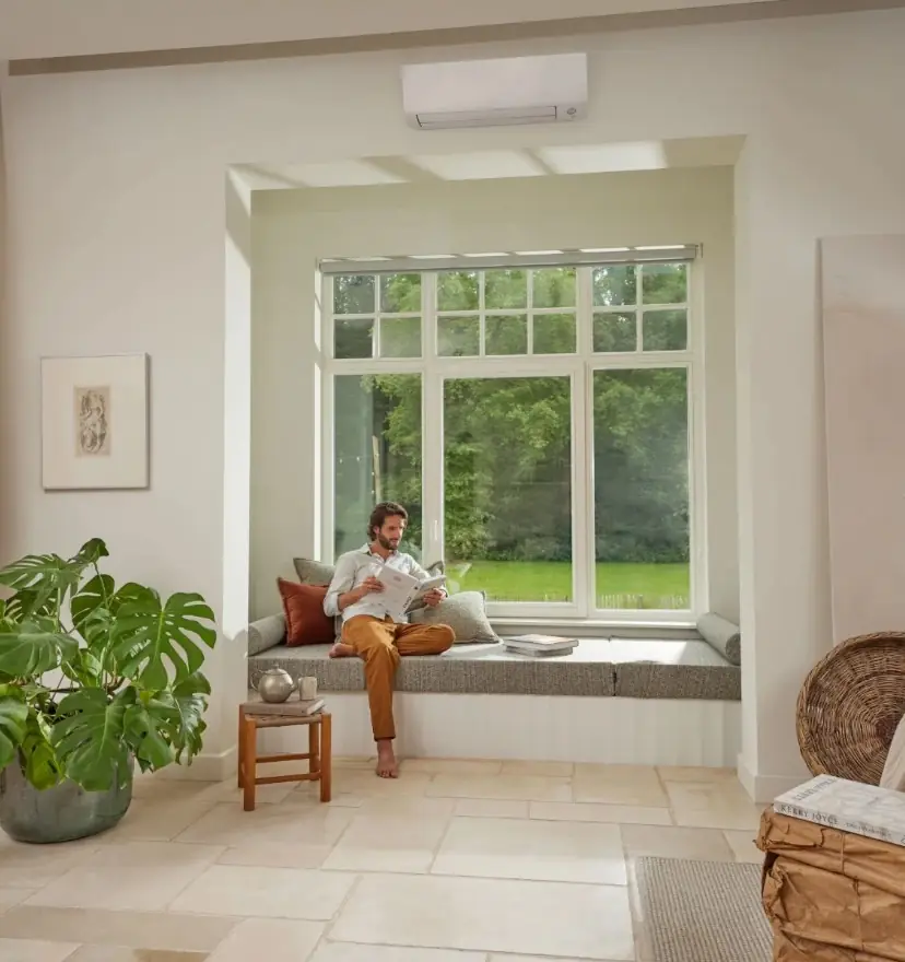 Wohnzimmer mit sauber montierter Klimaanlage über der Fensterfront