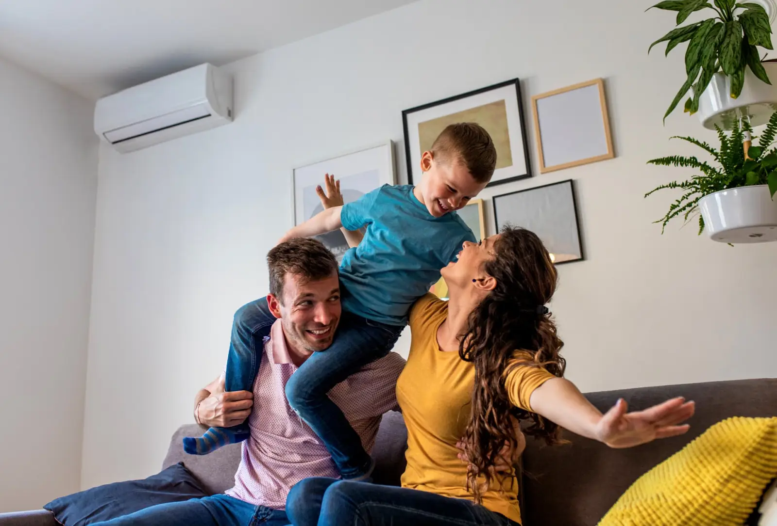 Glückliche Familie zu Hause unter einer Klimaanlage